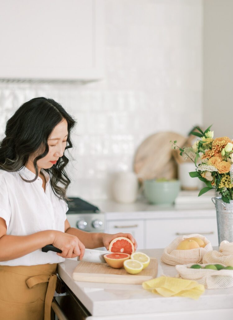 woman slicing fruit in a kitchen