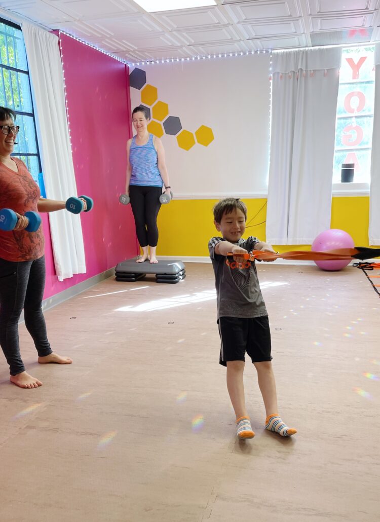 a kid at bee yoga fusion enjoying a workout with his mom in the small group personal training class