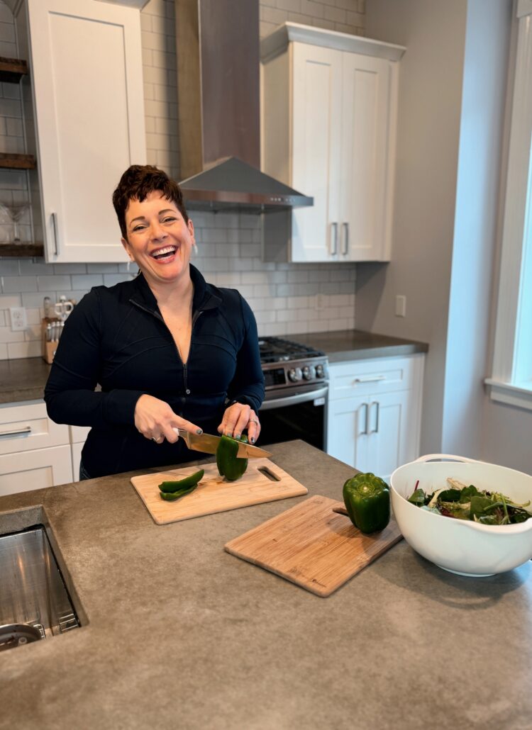 gretchen schock cutting a pepper to make a salad while smiling at the camera