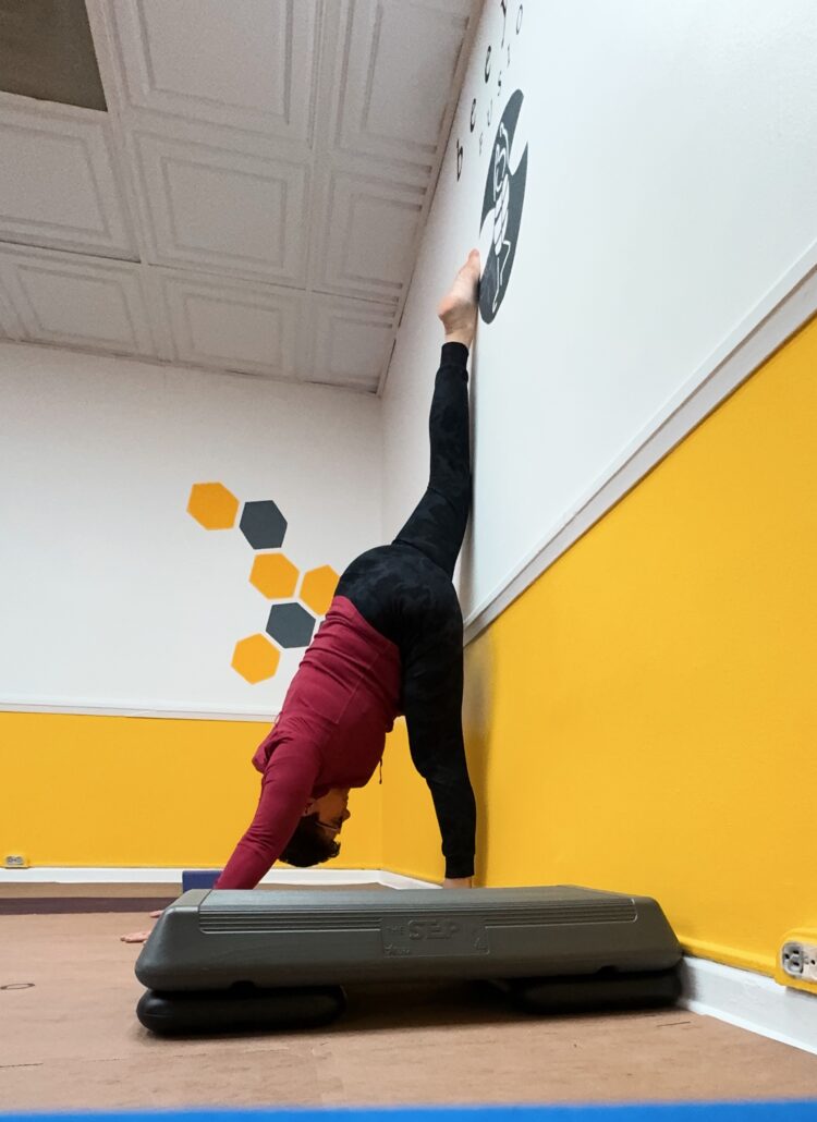 gretchen schock using a wall to do the splits at Bee Yoga Fusion