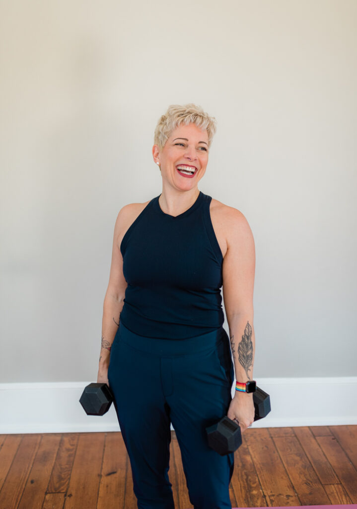 gretcchen schock with blonde hair holding hand weights and smiling