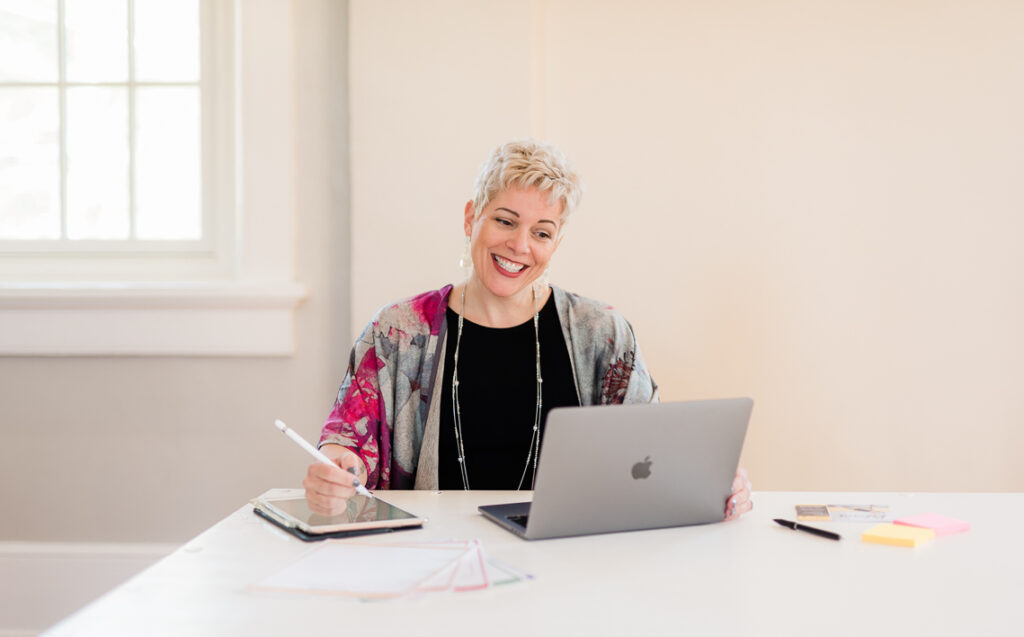 woman smiling into a computer on a zoom meeting