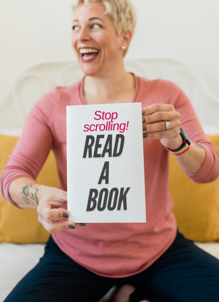 a short haired blonde woman holding a book in front of her that says "stop scrolling! Read a book"