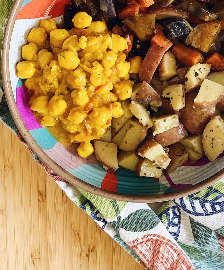 chickpea curry with a side of roasted potatoes and root vegetables
