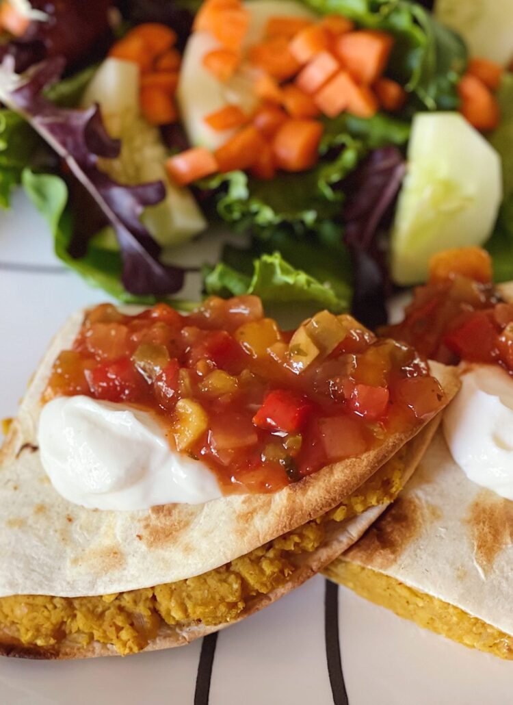 chickpea quesadilla with a side salad and salsa on top.