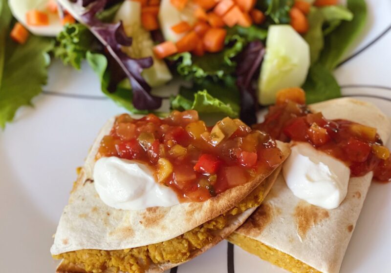 chickpea quesadilla with a side salad and salsa on top.