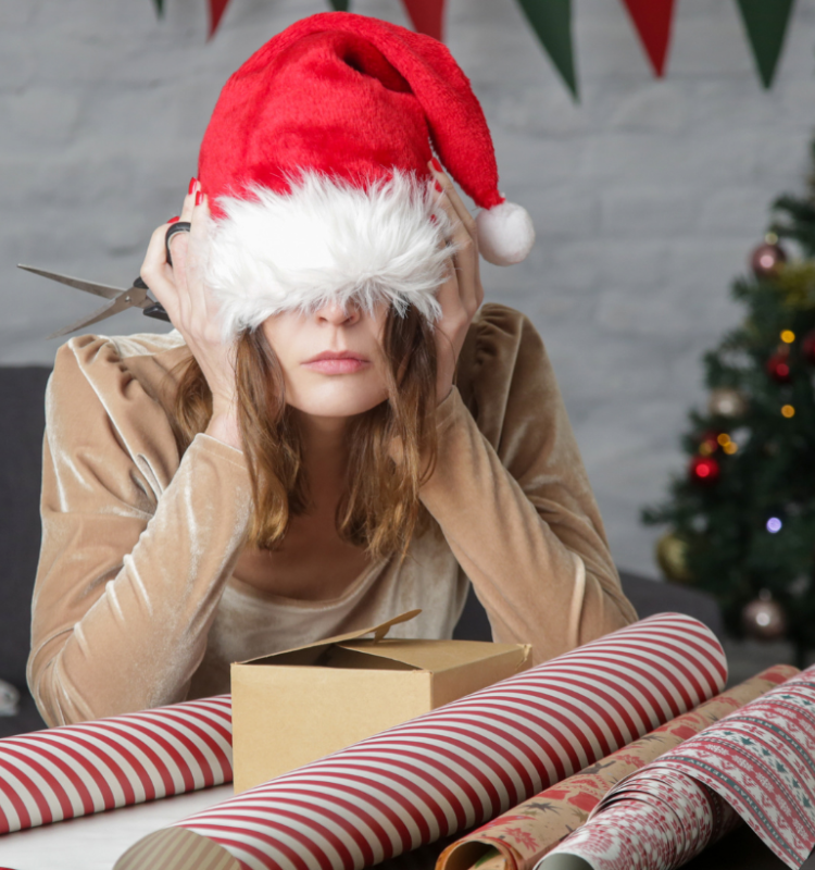 woman with a santa hat on looking overwhelmed