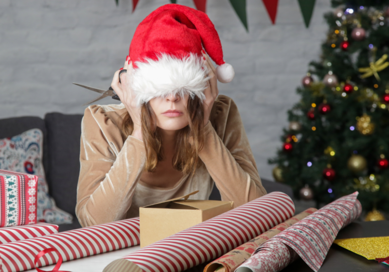 woman with a santa hat on looking overwhelmed