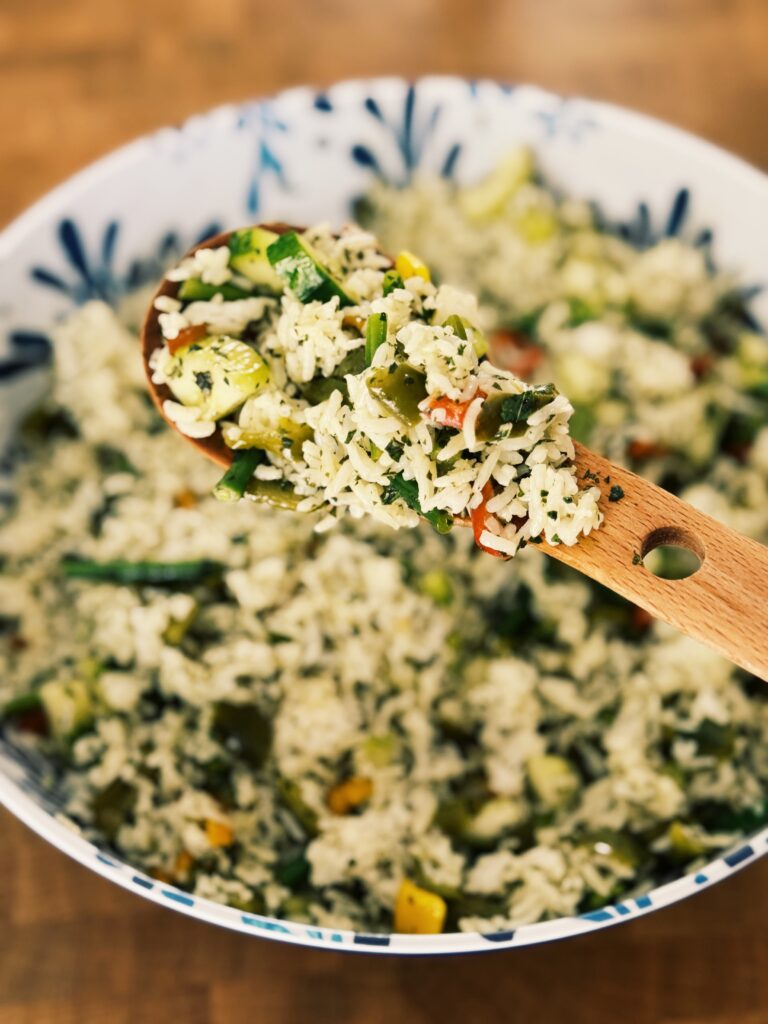 a wooden spoon holding a serving out of the bowl of the recipe that is written about