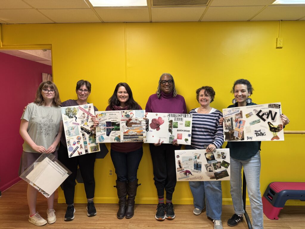 a group of women holding up their vision boards